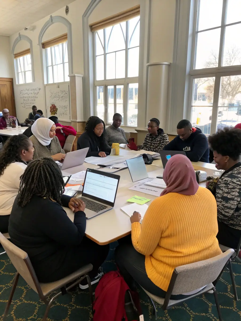 A photograph of residents attending a community meeting to discuss local issues and plan future initiatives, emphasizing democratic participation.